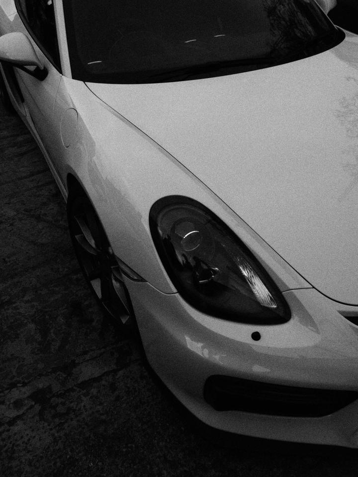 Close-up of a white Porsche GT4 headlight