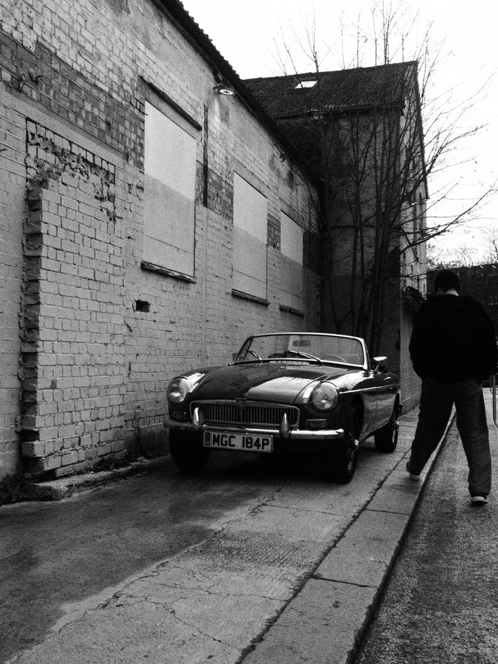 MGB Roadster parked along the old brick wall