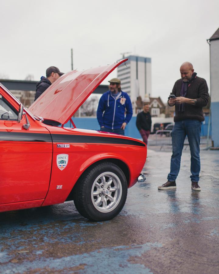 Red Ford Escort with the bonnet up and owners looking on
