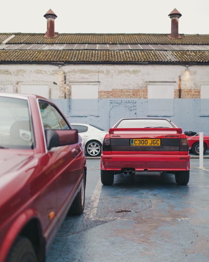 Red Audi Quattro parked by the blue wall