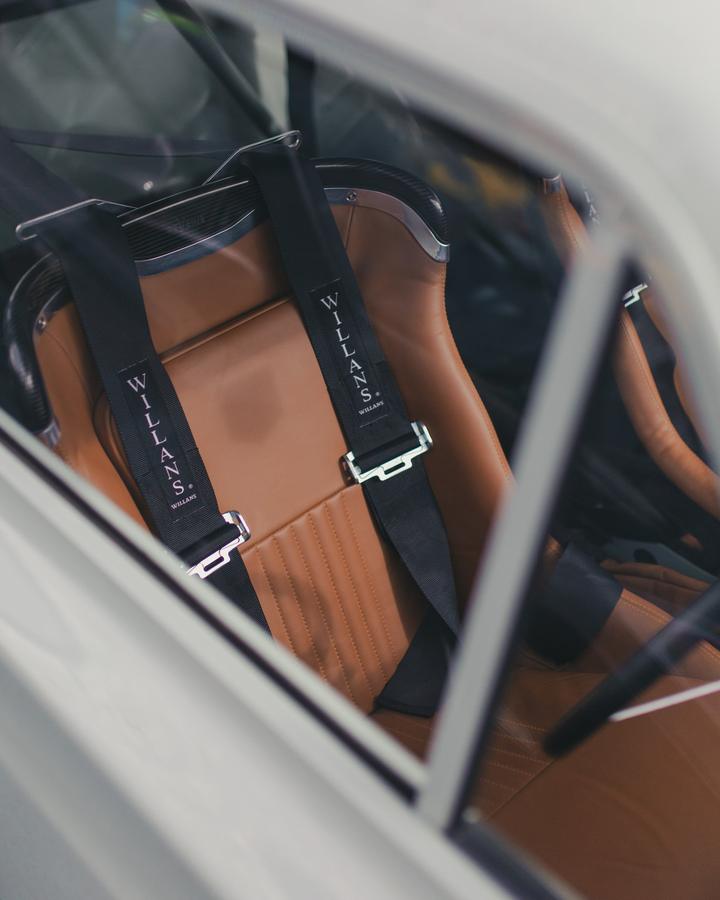 Willans harness on a tan leather bucket seat