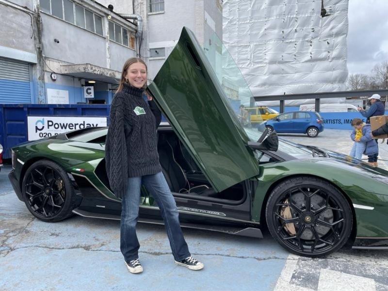 Thelma Deneef-Matthews next to a green Lamborghini Aventador with its door up